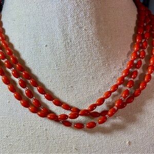 Triple strand red coral and clear seed beads.  Sterling silver closure.